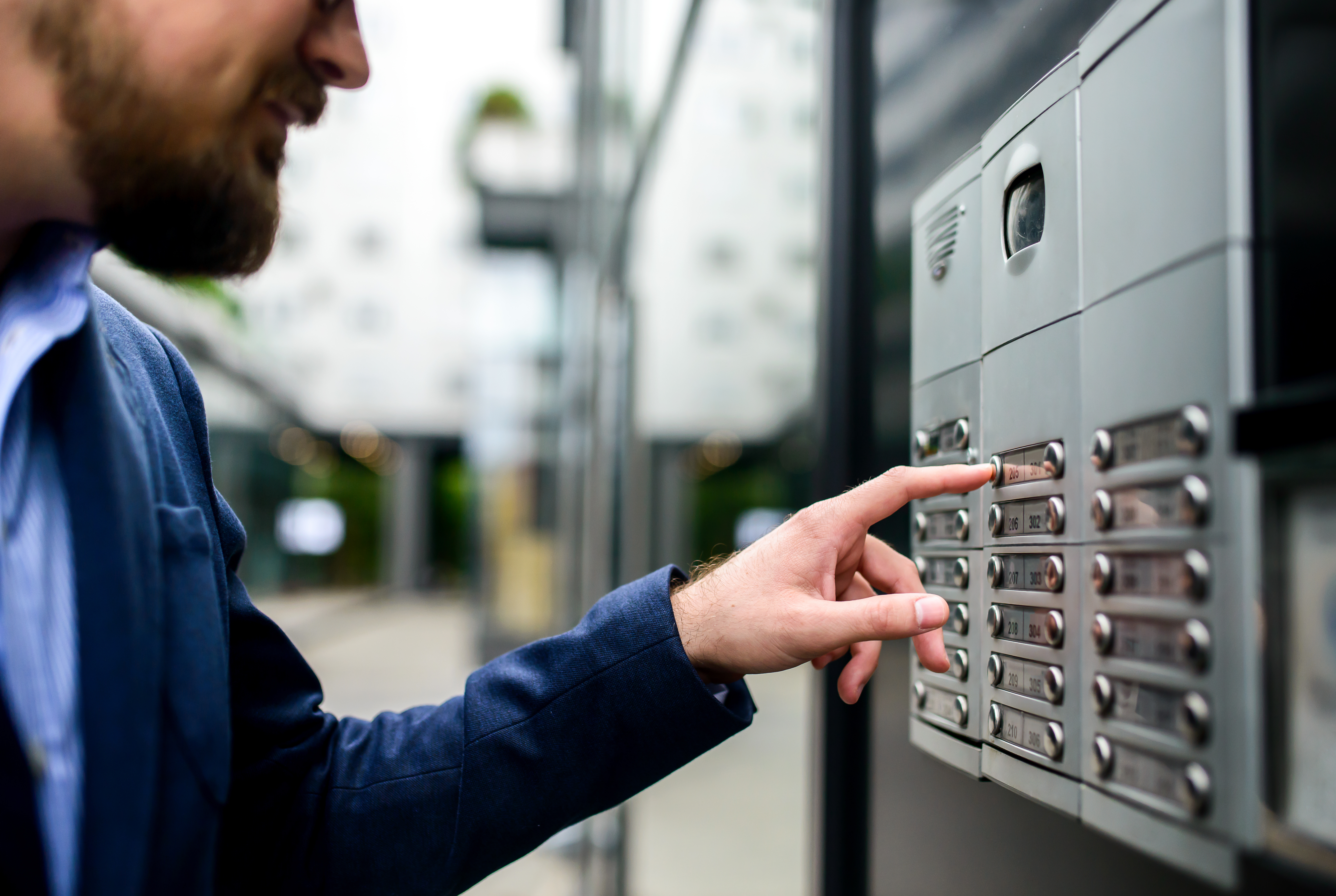 Man pushing the button and talking on the intercom sécurité établissements publics valais
